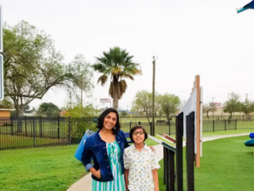 Judith and Jaythan standing in a park with an allergy awareness sign.