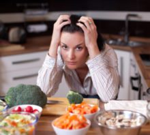 Sad woman in kitchen.