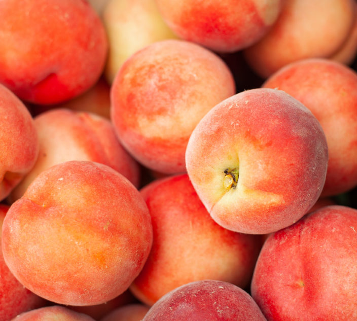 Picked peaches piled into a crate