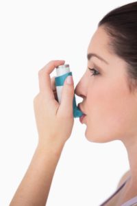 Woman using asthma inhaler