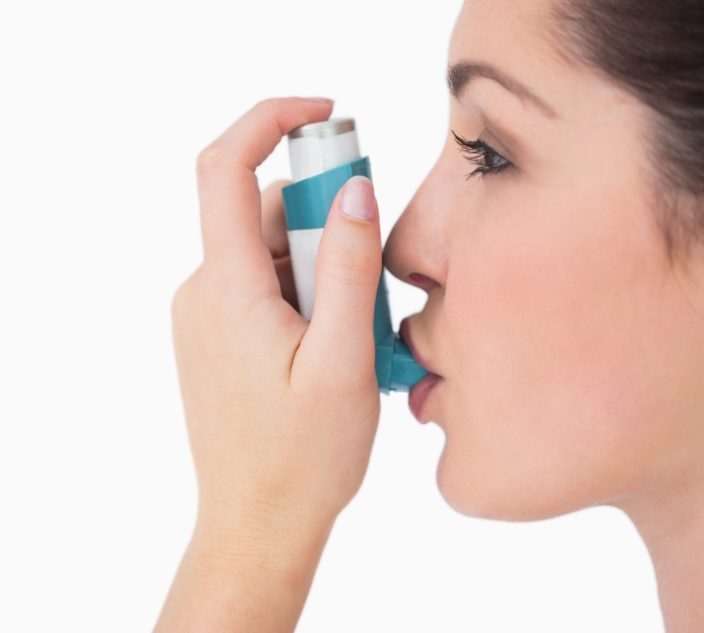 Woman using asthma inhaler