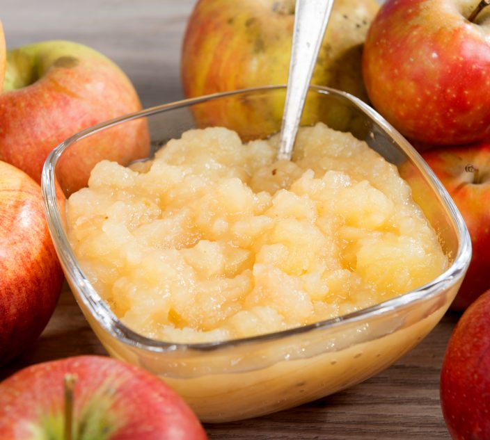 an applesauce with apples on a wooden table