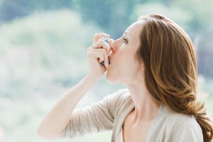 Woman using asthma inhaler
