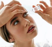 Woman with eye allergy using eye drops.