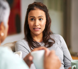 A woman discussing food allergies with a family member.