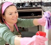 Happy woman is cleaning her home.