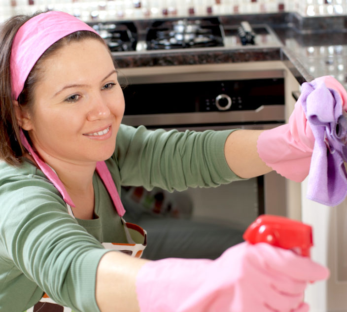 Happy woman is cleaning her home.