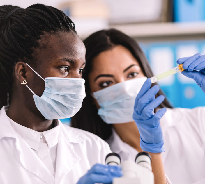 Doctors looking at vial while doing research.