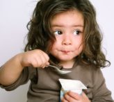 Little girl eating soy yogurt to avoid her eoe trigger.