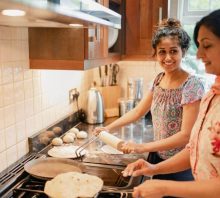 Teen and grandmother cooking together in the kitchen.