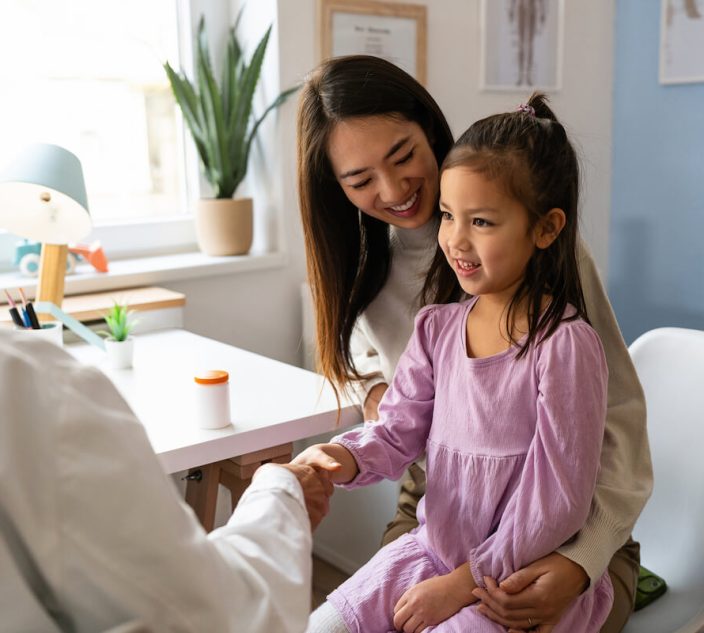 Japanese girl handshake with a female Caucasian pediatrician during an medical check-up
