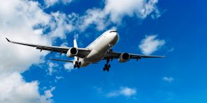 jet airplane landing in bright cloudy sky, panoramic frame