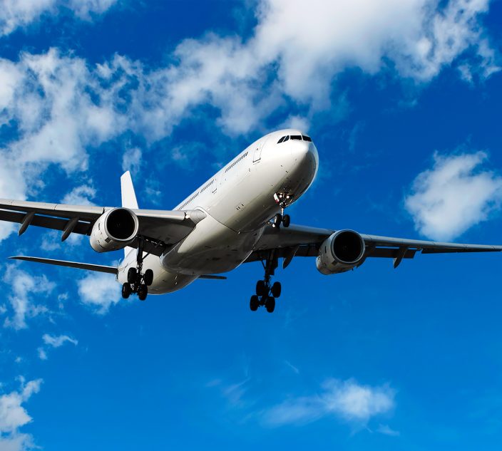 jet airplane landing in bright cloudy sky, panoramic frame